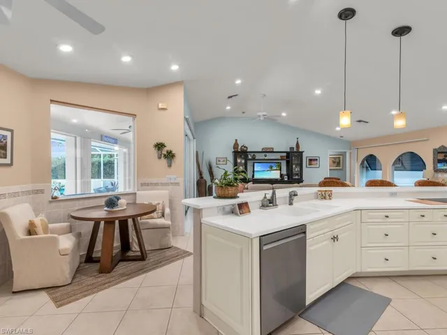 Kitchen with sink, dishwasher, ceiling fan, light tile patterned floors, and pendant lighting