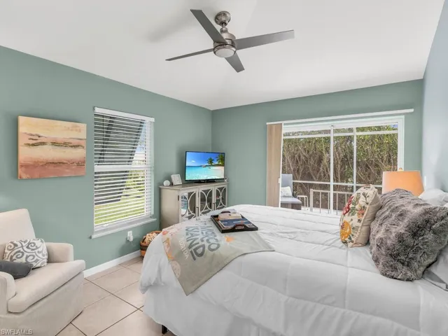 Tiled bedroom featuring ceiling fan