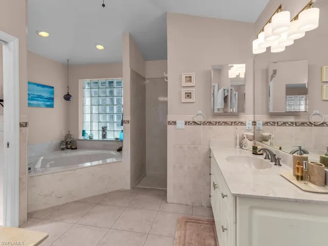 Bathroom featuring tile walls, vanity, independent shower and bath, and tile patterned floors