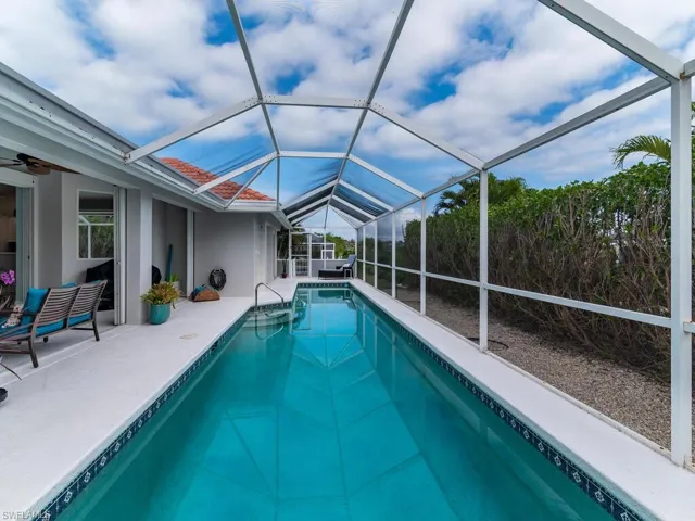 View of swimming pool with a patio, ceiling fan, and a lanai