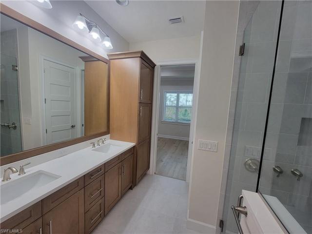 his and her vanity sinks with large linen and storage cabinet