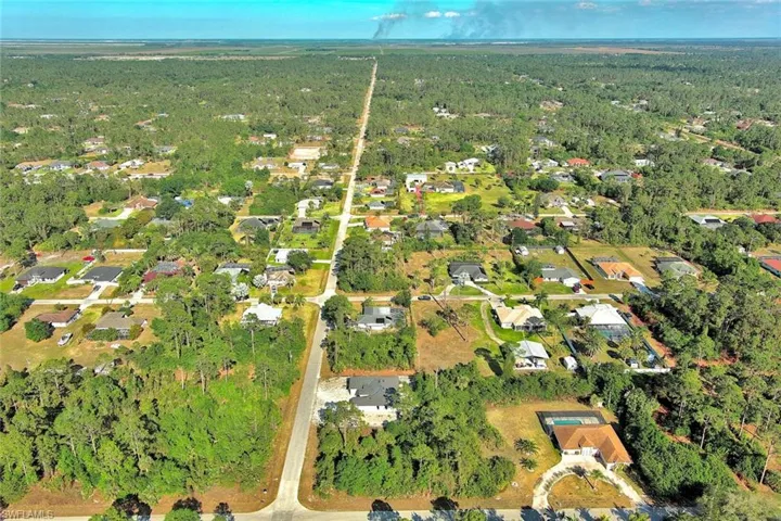 Aerial overview of property's location featuring nearby suburban area and a forest