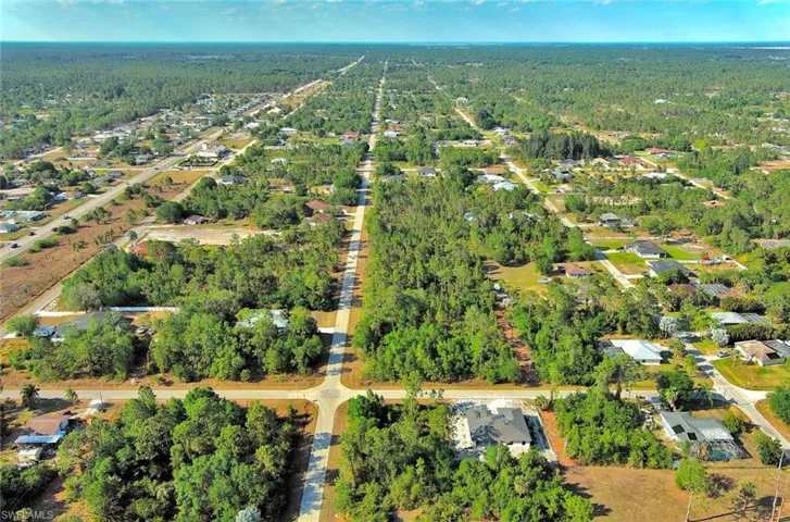 Aerial view of property and surrounding area featuring a heavily wooded area