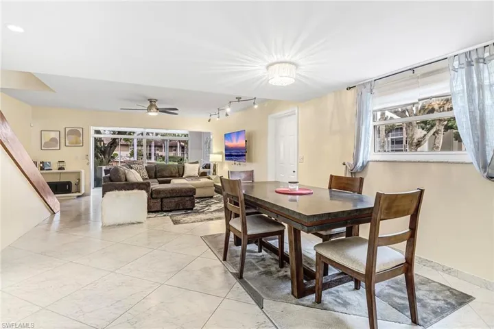 Dining area with ceiling fan, light marble finish flooring, and rail lighting