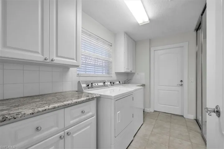 Laundry room has wonderful storage with cabinets and a closet.