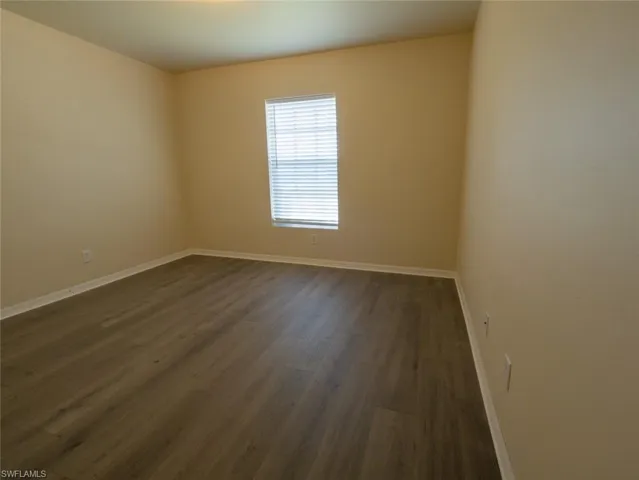 Spare room featuring dark wood-type flooring