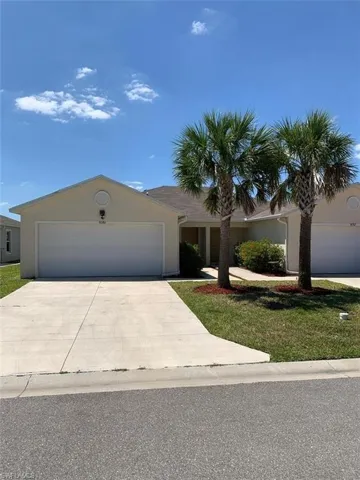 Single story home featuring concrete driveway, an attached garage, and stucco siding