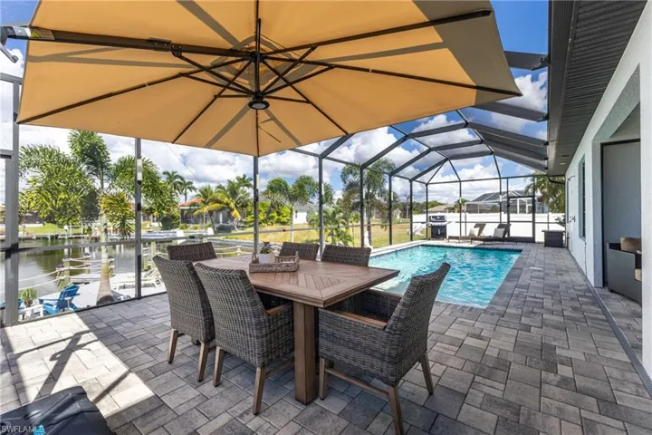 Swimming pool with a sunroom, a patio, and a lanai
