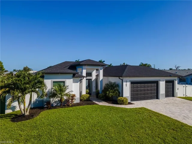 Prairie-style home featuring decorative driveway, stucco siding, a front lawn, and an attached garage