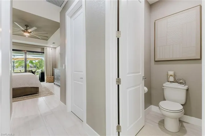 Ensuite bathroom with baseboards and ceiling fan