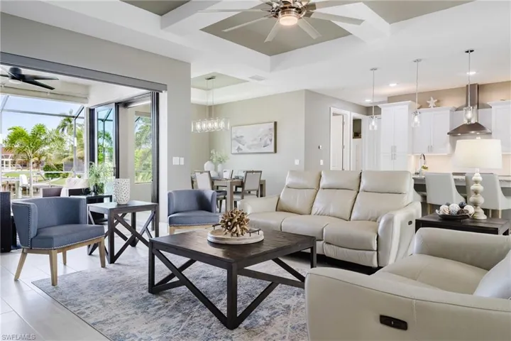 Living room with ceiling fan and beamed ceiling