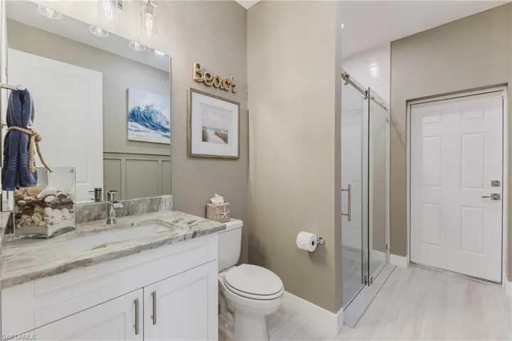 Full bathroom with vanity, a stall shower, and a textured wall