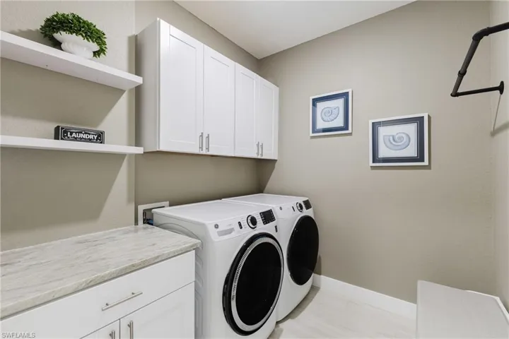 Washroom with cabinet space and washer and dryer