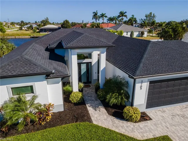 View of front of property with a residential view, stucco siding, an attached garage, and a shingled roof