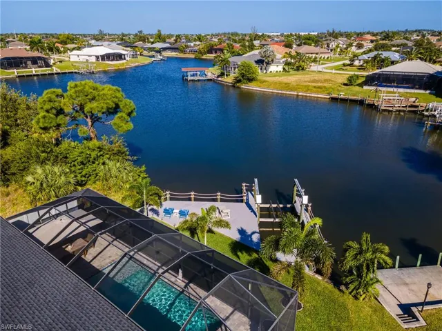 Aerial view of residential area featuring a large body of water and a pool area