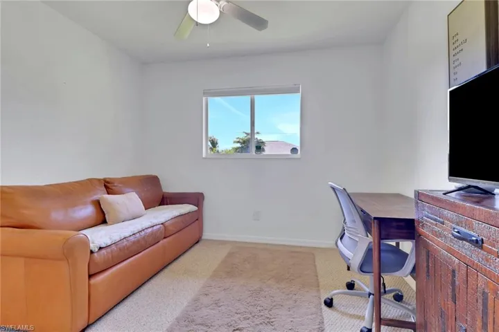 Office space with light carpet and ceiling fan