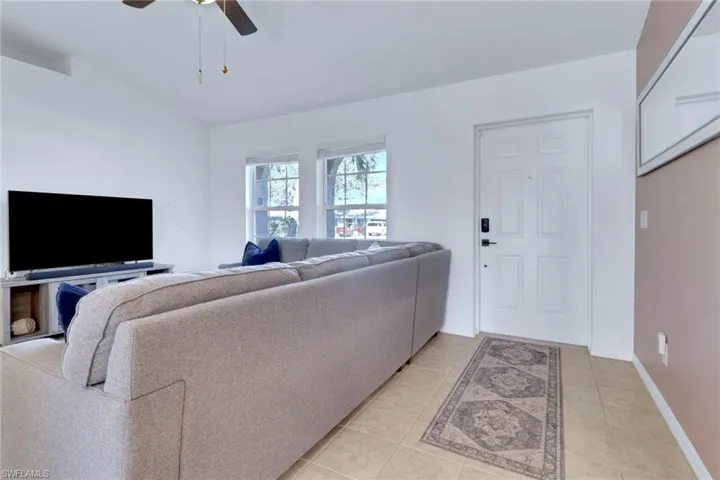 Living room featuring light tile patterned flooring and a ceiling fan