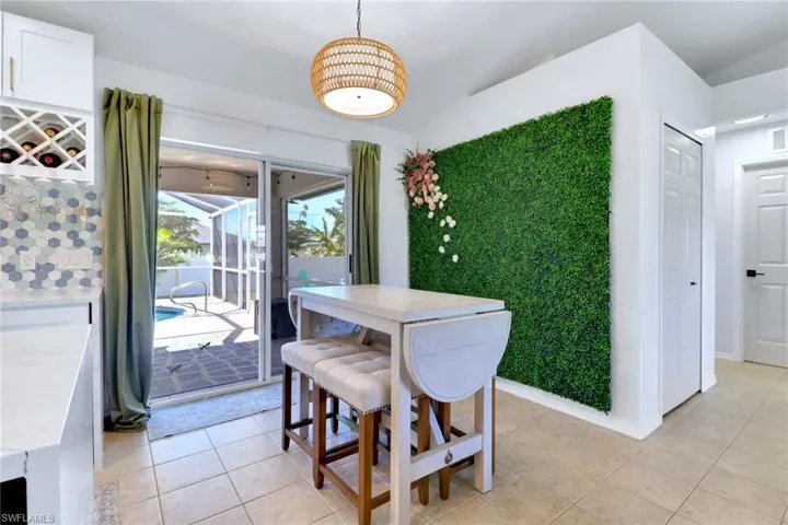 Dining space with light tile patterned floors and lofted ceiling