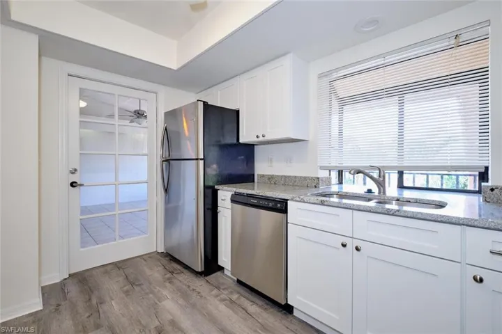 Kitchen featuring white cabinetry, granite countertops, and stainless steel appliances