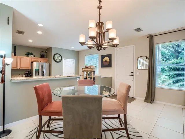 Tiled dining space featuring a notable chandelier and a wealth of natural light