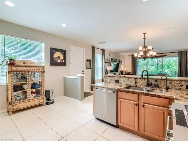 Kitchen featuring light tile patterned floors, sink, a wealth of natural light, and stainless steel dishwasher