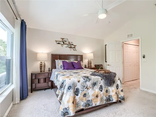 Bedroom featuring vaulted ceiling, a closet, carpet floors, and ceiling fan