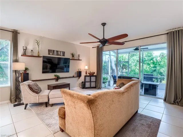 Living room featuring light tile patterned floors and ceiling fan