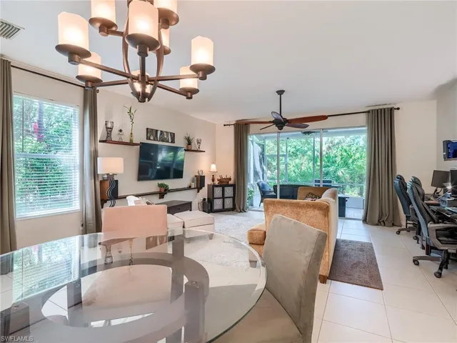 Tiled dining room featuring a wealth of natural light and ceiling fan with notable chandelier