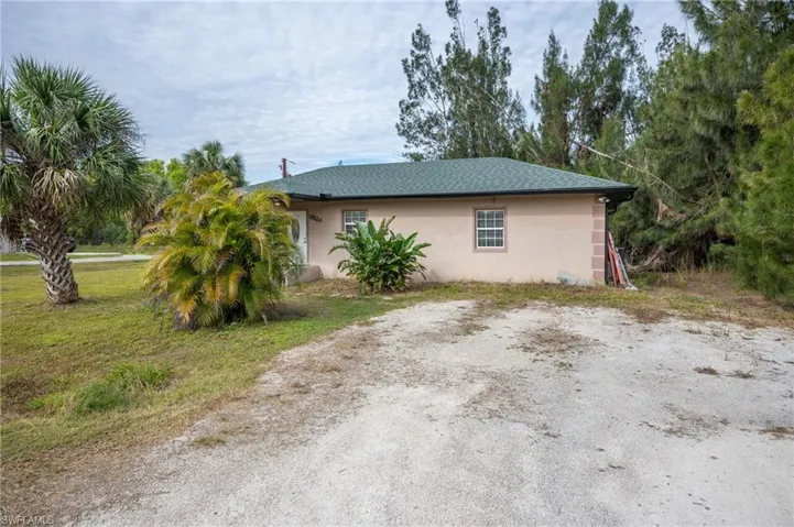 View of side of home with stucco siding and a lawn
