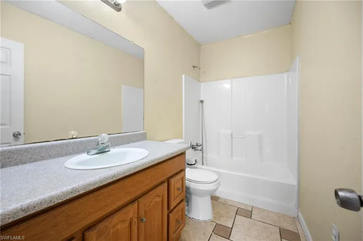 Full bathroom featuring toilet, vanity, and shower / tub combination