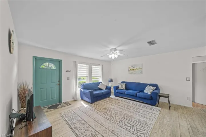 Living room featuring light wood-type flooring and a ceiling fan