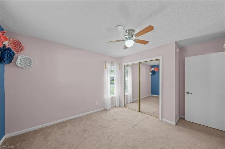 Unfurnished bedroom featuring carpet, a textured ceiling, ceiling fan, and a closet
