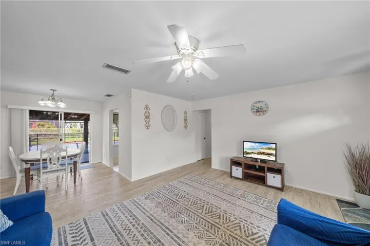 Living area featuring a chandelier, wood finished floors, and a ceiling fan