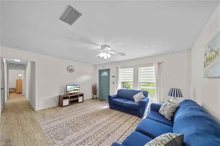 Living room with light wood-style flooring and ceiling fan