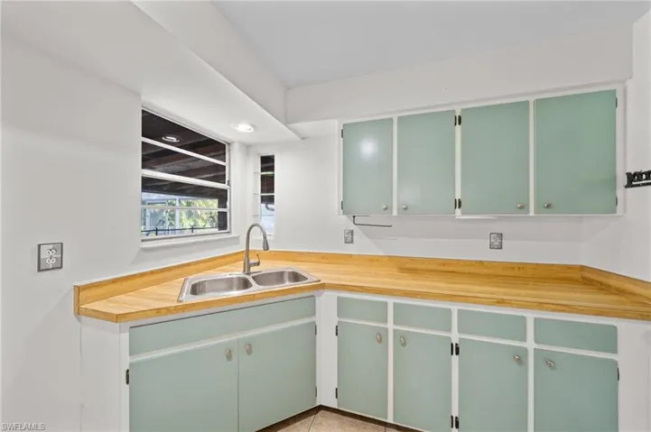 Kitchen featuring green cabinetry, light countertops, and light tile patterned flooring