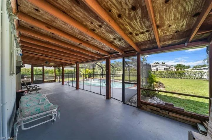 Unfurnished sunroom with a ceiling fan and a patio area