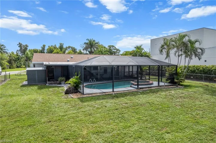 Back of house featuring a fenced backyard, a lanai, and a sunroom