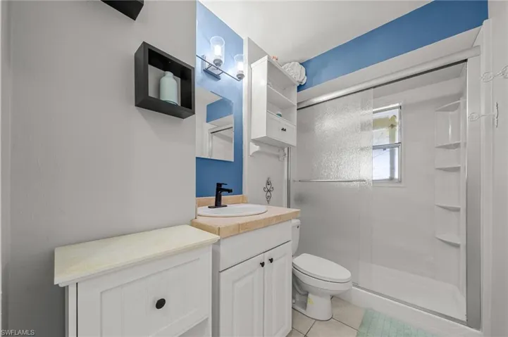 Bathroom featuring vanity, a stall shower, and light tile patterned floors