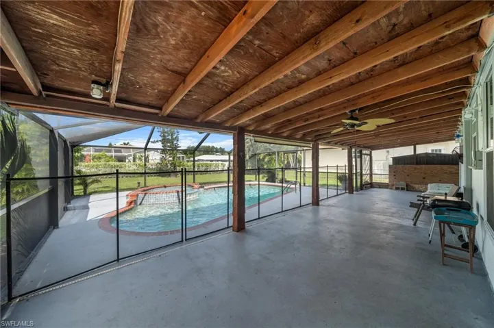 View of swimming pool featuring a sunroom, ceiling fan, and a pool with connected hot tub