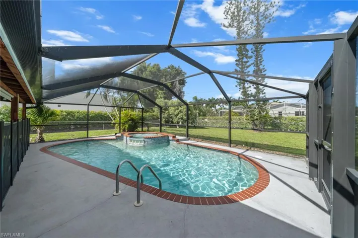 View of pool featuring a sunroom, a patio area, a pool with connected hot tub, and a lanai