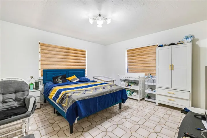 Bedroom with a textured ceiling and light tile patterned floors