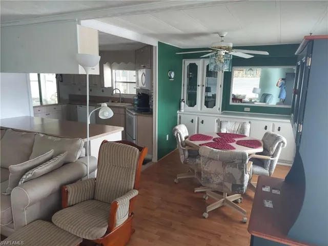 Dining area featuring ornamental molding, wood-type flooring, sink, and ceiling fan