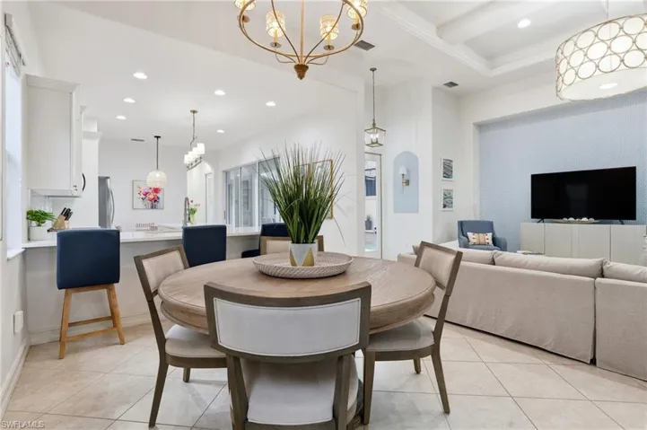 Dining space featuring light tile patterned floors, recessed lighting, and a chandelier