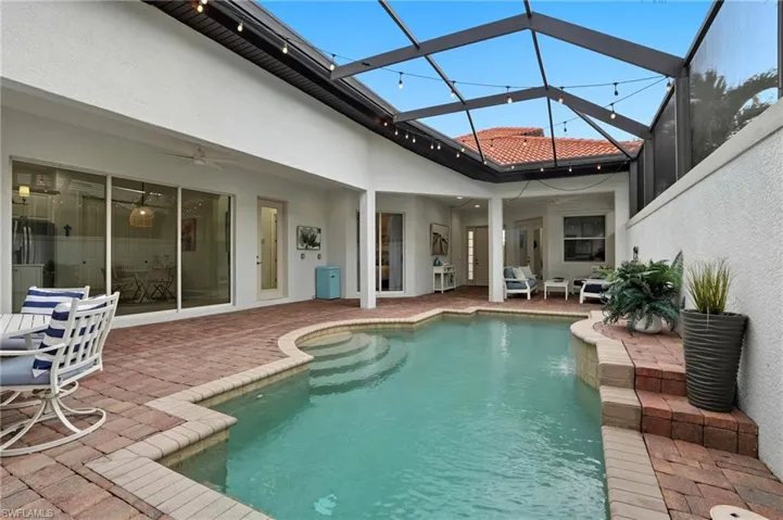 Back of house with stucco siding, ceiling fan, a patio, and an outdoor pool