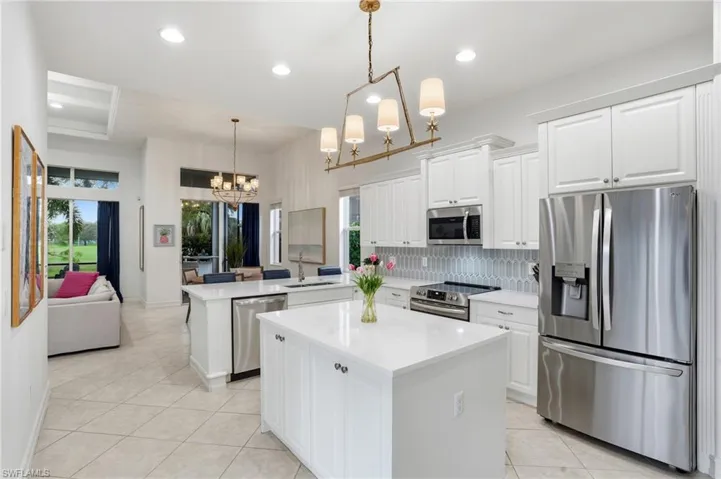 Kitchen featuring stainless steel appliances, tasteful backsplash, white cabinetry, light tile patterned flooring, and recessed lighting