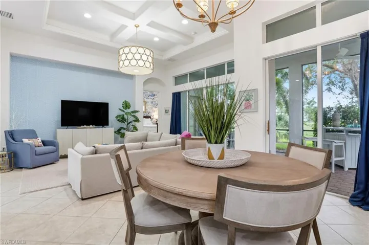 Dining space with coffered ceiling, beam ceiling, a high ceiling, arched walkways, and light tile patterned floors