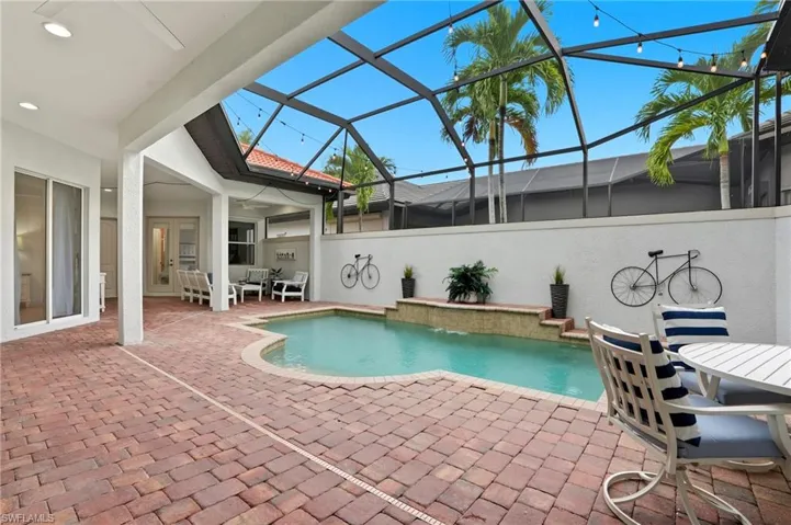 Swimming pool with a patio area, a lanai, a sunroom, outdoor dining area, and a ceiling fan