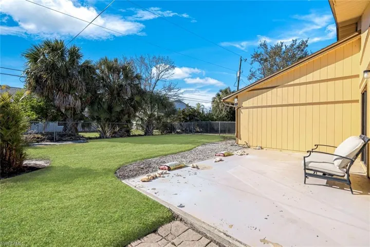 Outside patio at back of home with nice green space and fenced yard
