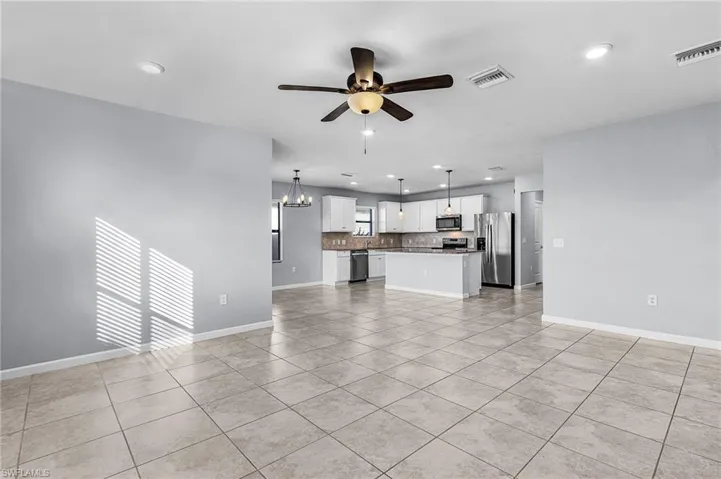 Living room featuring a chandelier, light tile patterned floors, ceiling fan, and recessed lighting