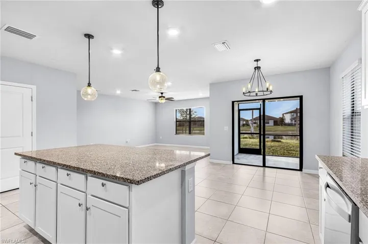 Kitchen featuring white cabinetry, light fixtures, granite countertops, a kitchen island, and recessed lighting